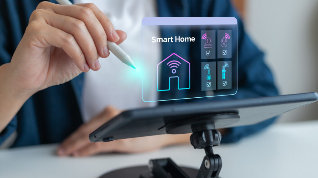 Ein Tablet mit Smarthome-Automatisierungshologramm ist vor einer Person platziert. Die Person hat einen Bedienungsstift in der Hand.