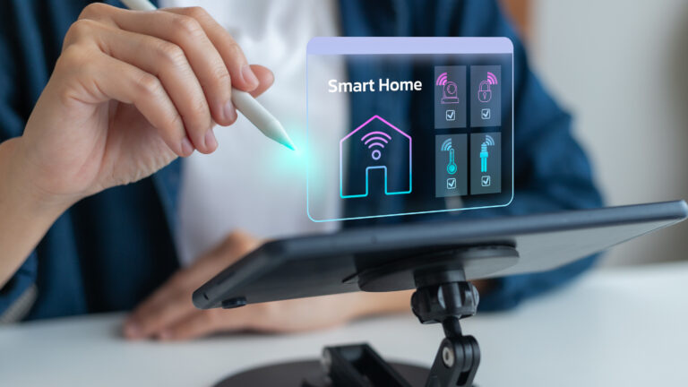 Ein Tablet mit Smarthome-Automatisierungshologramm ist vor einer Person platziert. Die Person hat einen Bedienungsstift in der Hand.
